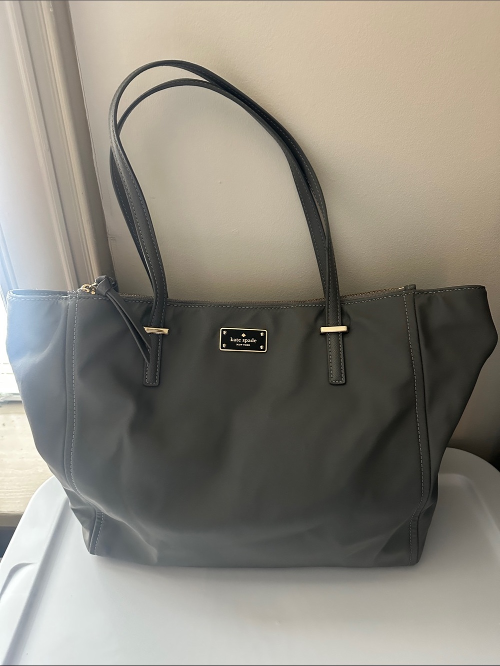 kate spade dark gray nylon tote with black and gold logo plaque